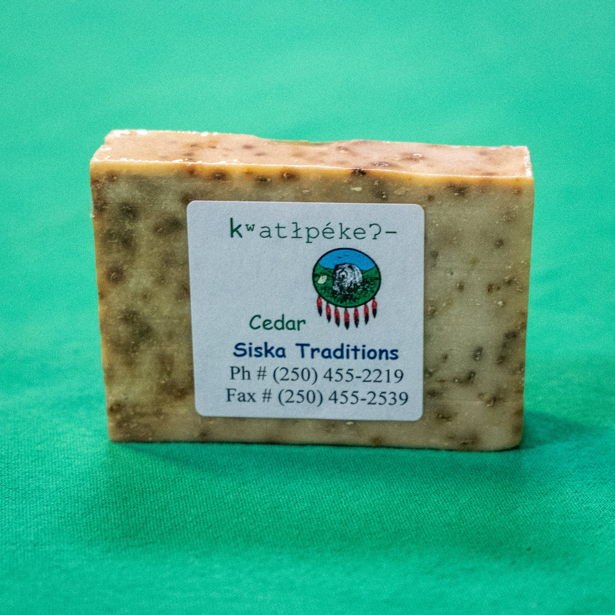 A bar of soap. A label on the soap says "Cedar Siska Traditions. Phone: 250-455-2219. Fax: 250-455-2539." End of image description. 