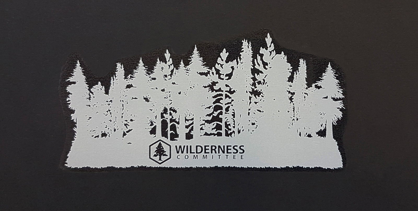 A decal of a forest filled with different trees, with the Wilderness Committee's logo at the bottom. End of image description.