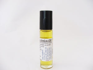 A bottle of yellow oil. The label on the bottle says "Arnica Oil". End of image description.