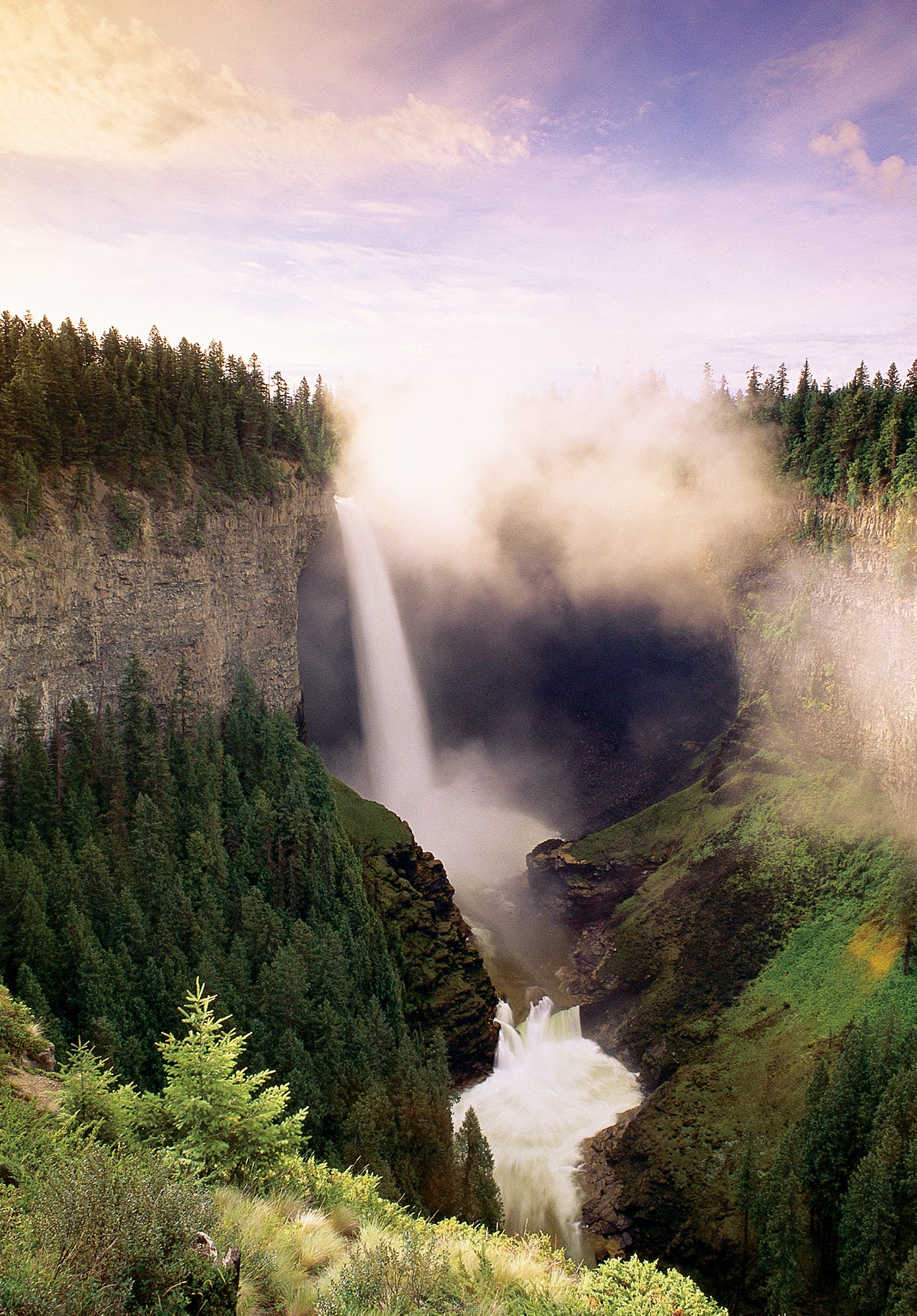 A photo of a waterfall and forests. End of image description.