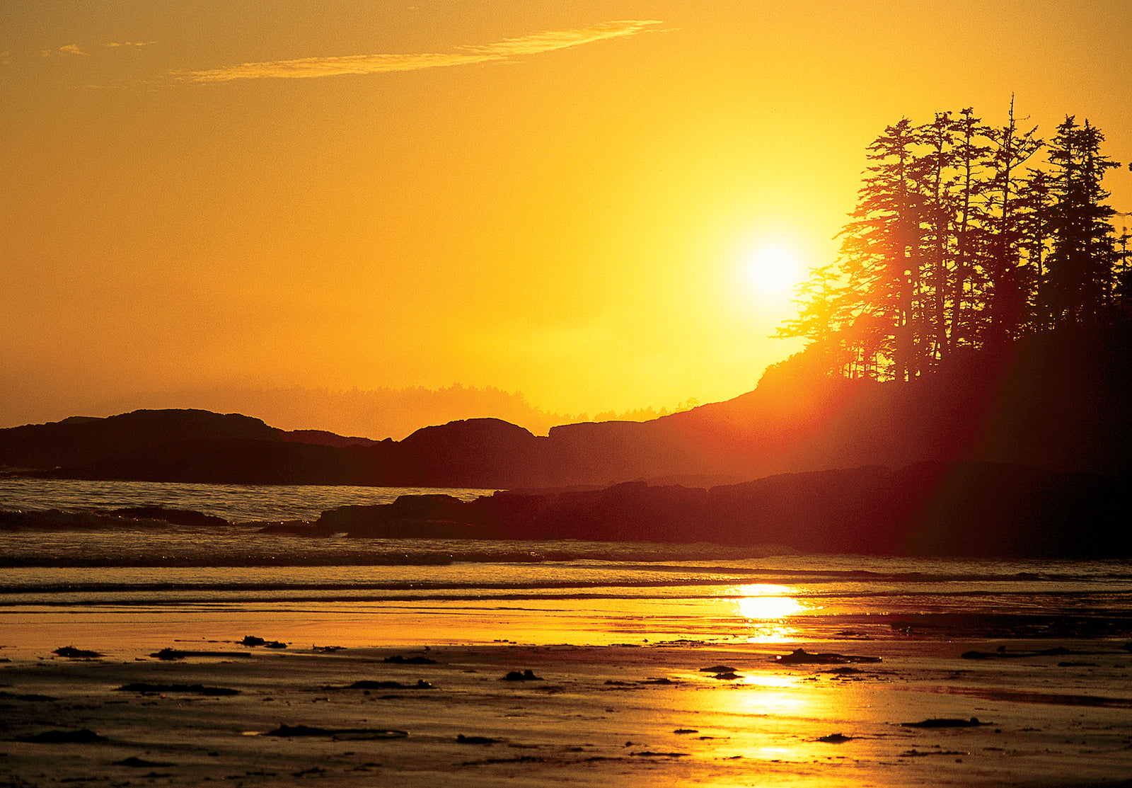 A shot of the sun setting on a beach. End of image description.