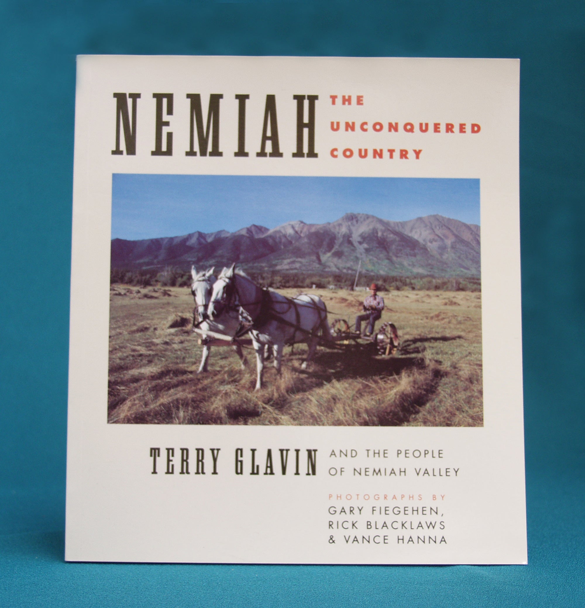 A book cover with a photo of horses pulling farm equipment. Text on the image says "Nemiah - The Unconquered Country. Terry Glavin and the people of the Nemiah Valley. Photographs by Gary Fiegehen, Rick Blacklaws, and Vance Hanna." End of image description.