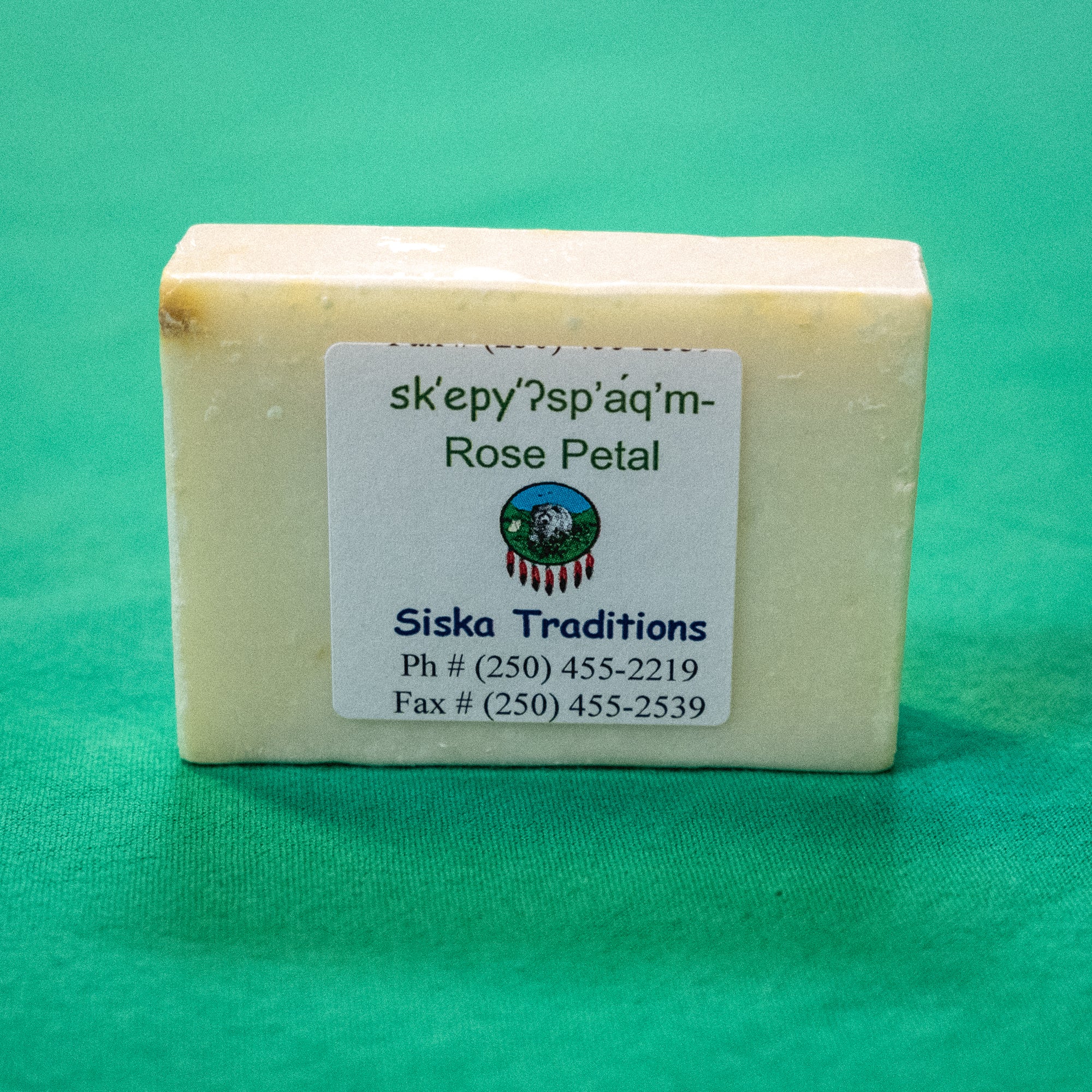 A bar of soap with a label on it that says "Rose petal. Siska Traditions. Phone: 250-455-2219. Fax: 250-455-2539." End of image description.